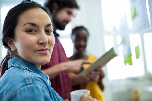 Female graphic designer holding a cup of coffee