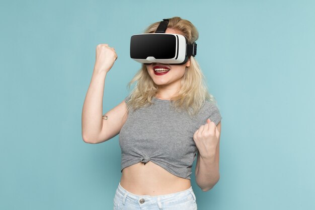 female in grey shirt and bright blue jeans playing vr