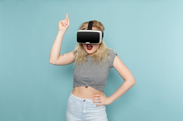 female in grey shirt and bright blue jeans playing vr