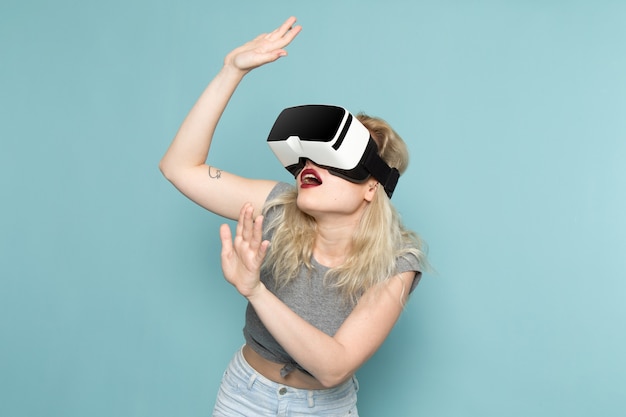 female in grey shirt and bright blue jeans playing vr