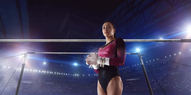 Female gymnast doing a complicated trick on gymnastics balance beam in a professional arena