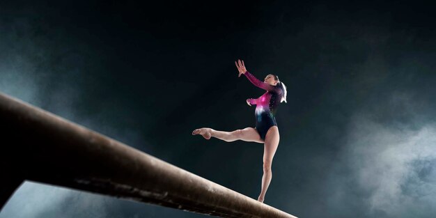 Female gymnast doing a complicated trick on gymnastics balance beam in a professional arena