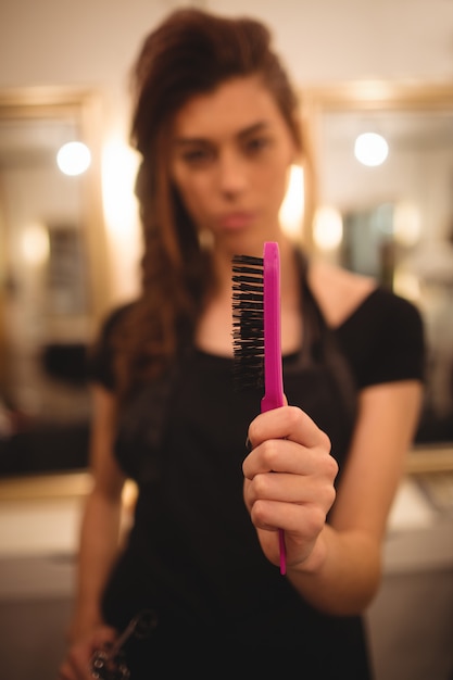 Free photo female hairdresser holding hairbrush