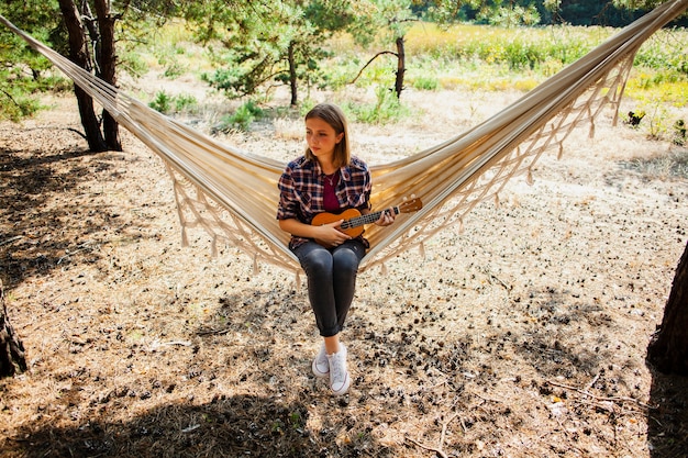 Free photo female in hammock with quitar