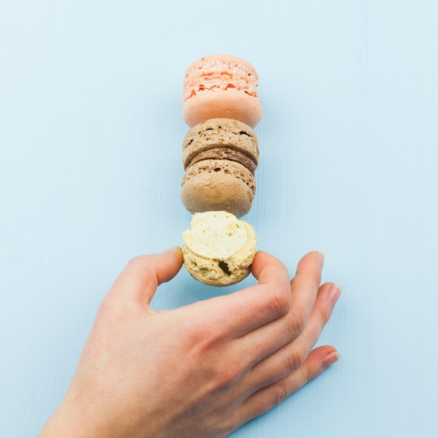 Free photo female hand taking tasty macaroons