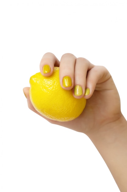 Free Photo female hand with glitter manicure holding lemon