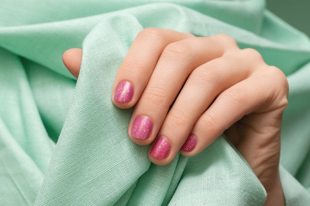 Free Photo female hand with pink glitter nail design