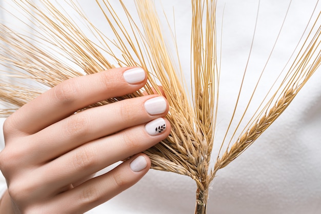 Free Photo female hand with white nail design, close up.