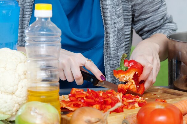 Female hands cuts pepper