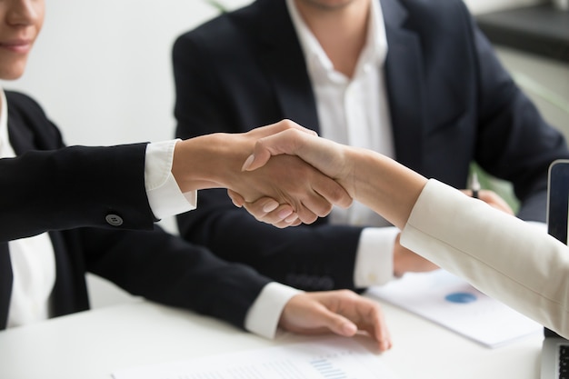 Free photo female hands shaking at group meeting making partnership deal, closeup