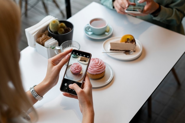 Free photo female hands taking photo of a muffin