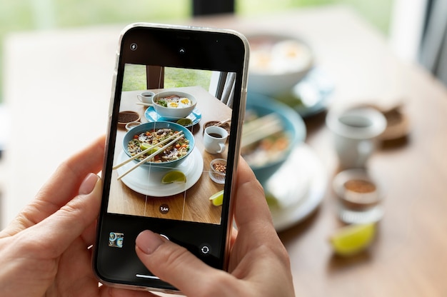 Female hands taking photo of two bowls of ramen