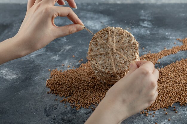 Female hands tying rice cake on marble surface