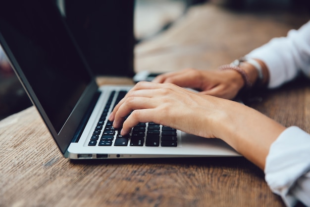 Female hands typing on keyboard of netbook, close-up view. Business concept.