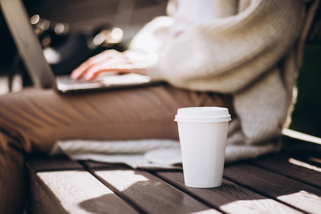 Free Photo female hands typing on laptop with coffee cup in focus