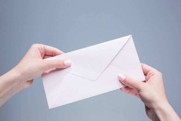 Free photo female hands with the envelope against the gray background