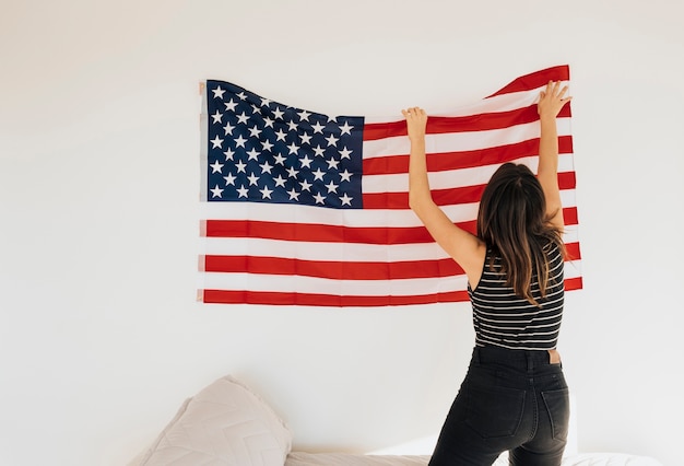 Free photo female hanging national flag on wall