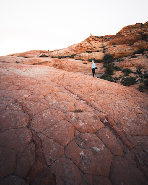 Free Photo female hiker with a backpack on a rocky desert hills