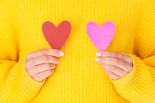 Free photo female holding paper hearts front view