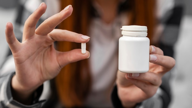 Female holding white pill close up