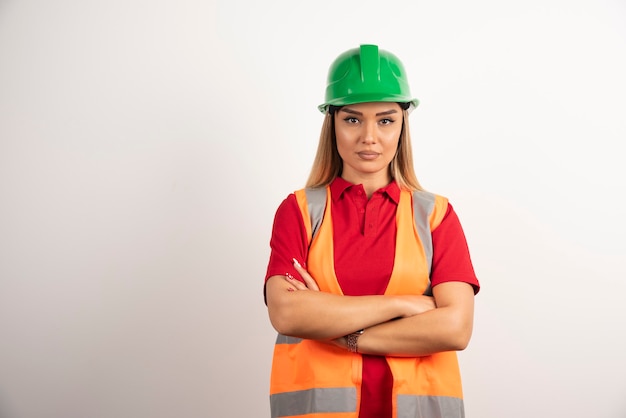 Female industrial worker posing in uniform and hardhat.