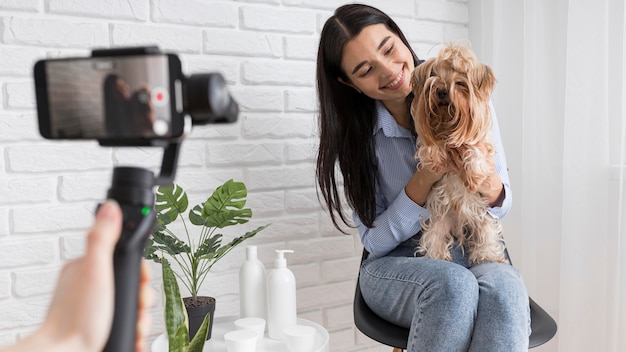 Female influencer at home with smartphone and pet