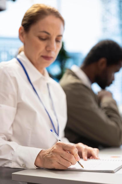 Free photo female investor takes notes during financial projection in a meeting