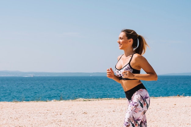 Free Photo female jogger running near the sea at beach