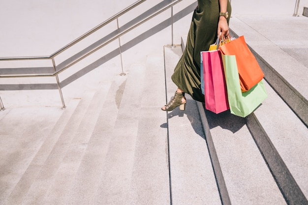 Free photo female legs with shopping bags going downstairs