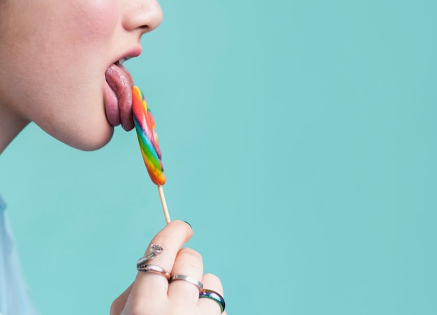 Free photo female licking lollipop copy space