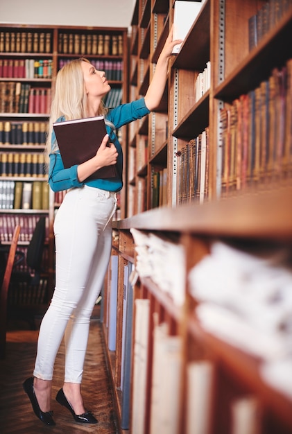 Free Photo female looking for a book in the library