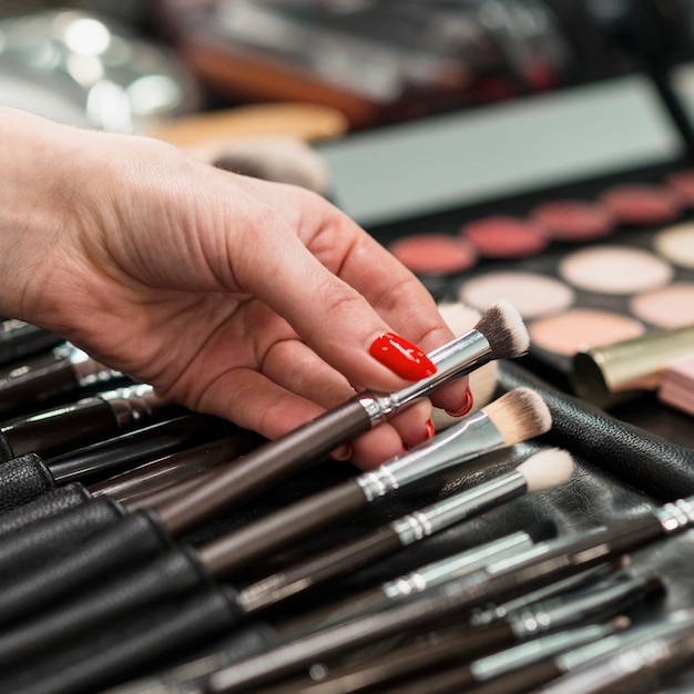 Female makeup artist with collection of professional brushes