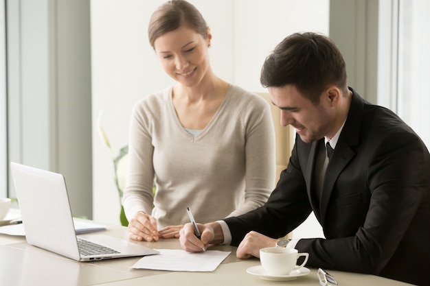 Female and male business leaders signing contract