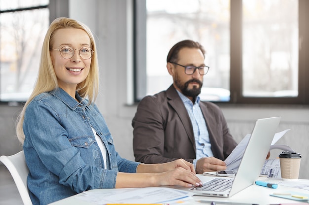 Free photo female and male economists work with documents and modern technologies