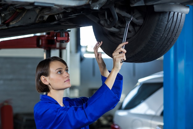 Free Photo female mechanic fixing a car wheel disc brake