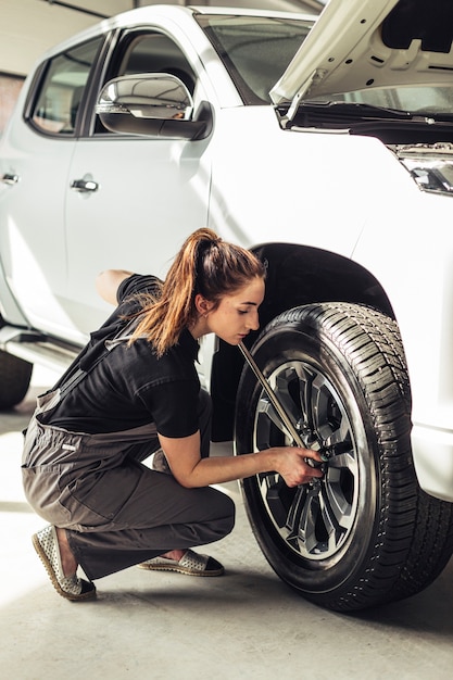 Female mechanic fixing car wheels