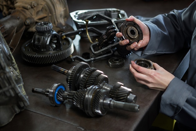 Free photo female mechanic holding spare parts of car