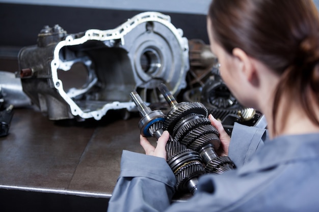 Female mechanic holding spare parts