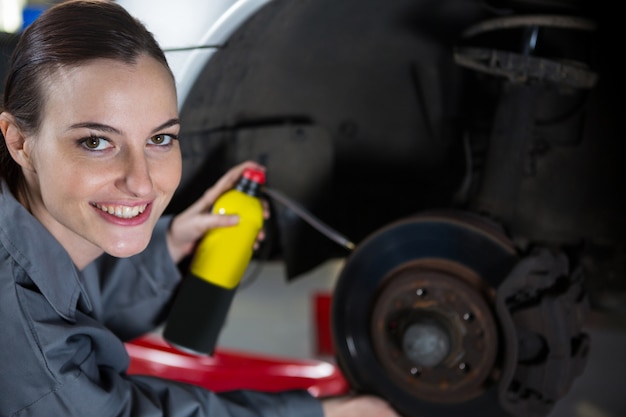 Free Photo female mechanic oiling car brake