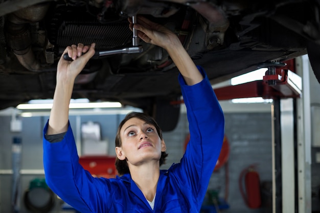 Female mechanic servicing a car