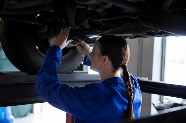 Female mechanic servicing a car