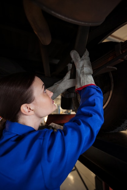 Female mechanic servicing a car