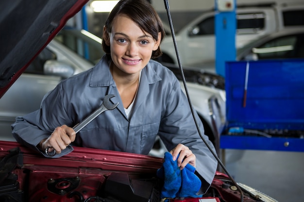 Female mechanic servicing car