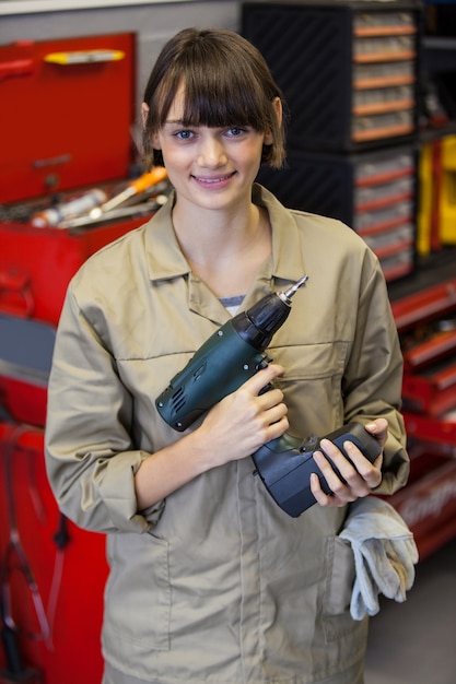 Female mechanic with pneumatic wrench