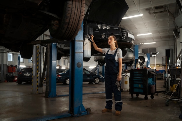 Female mechanic working in the shop on a car