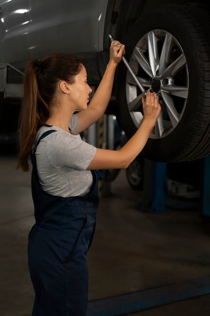 Female mechanic working in the shop on a car