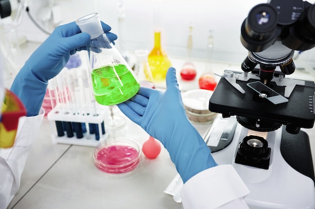 A female medical or scientific researcher or woman doctor looking at a test tube