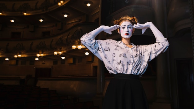 Free Photo female mime standing in auditorium posing