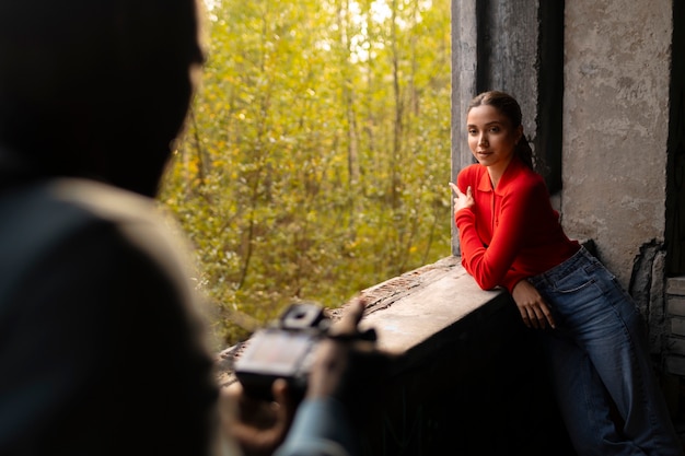 Free photo female model being photographed with grunge environment during urban exploration