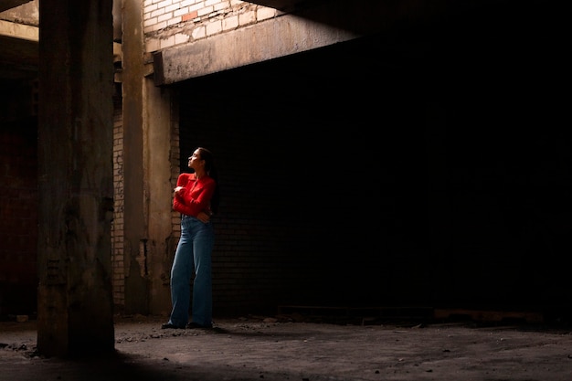 Free photo female model being photographed with grunge environment during urban exploration